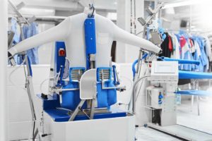 Shirt laundry pressing line at Joe’s Organic Dry Cleaners with dress shirts being professionally pressed